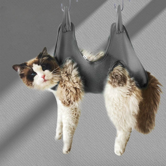 a cute white and brown cat hanged by a grooming gray hammock for nail cutting no scratching comfortable hammock