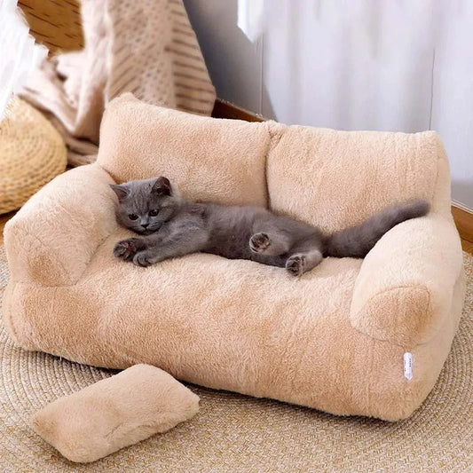 a cute dark gray cat sleeping on a comfy plush beige sofa