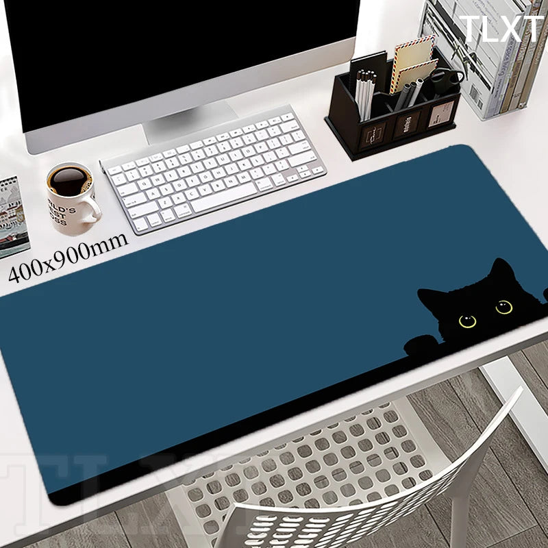 white computer desk with a very cute blue rectangular keypad with drawing of a cute black cat face peaking with cute yellow sparkly eyes 