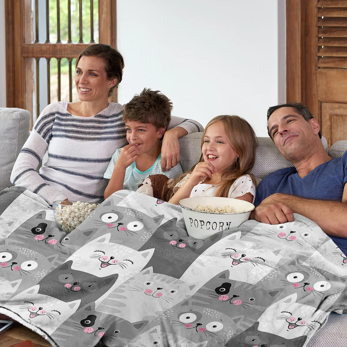 family watching a movie and eating popcorn under the cozy gray cotton cat blanket 