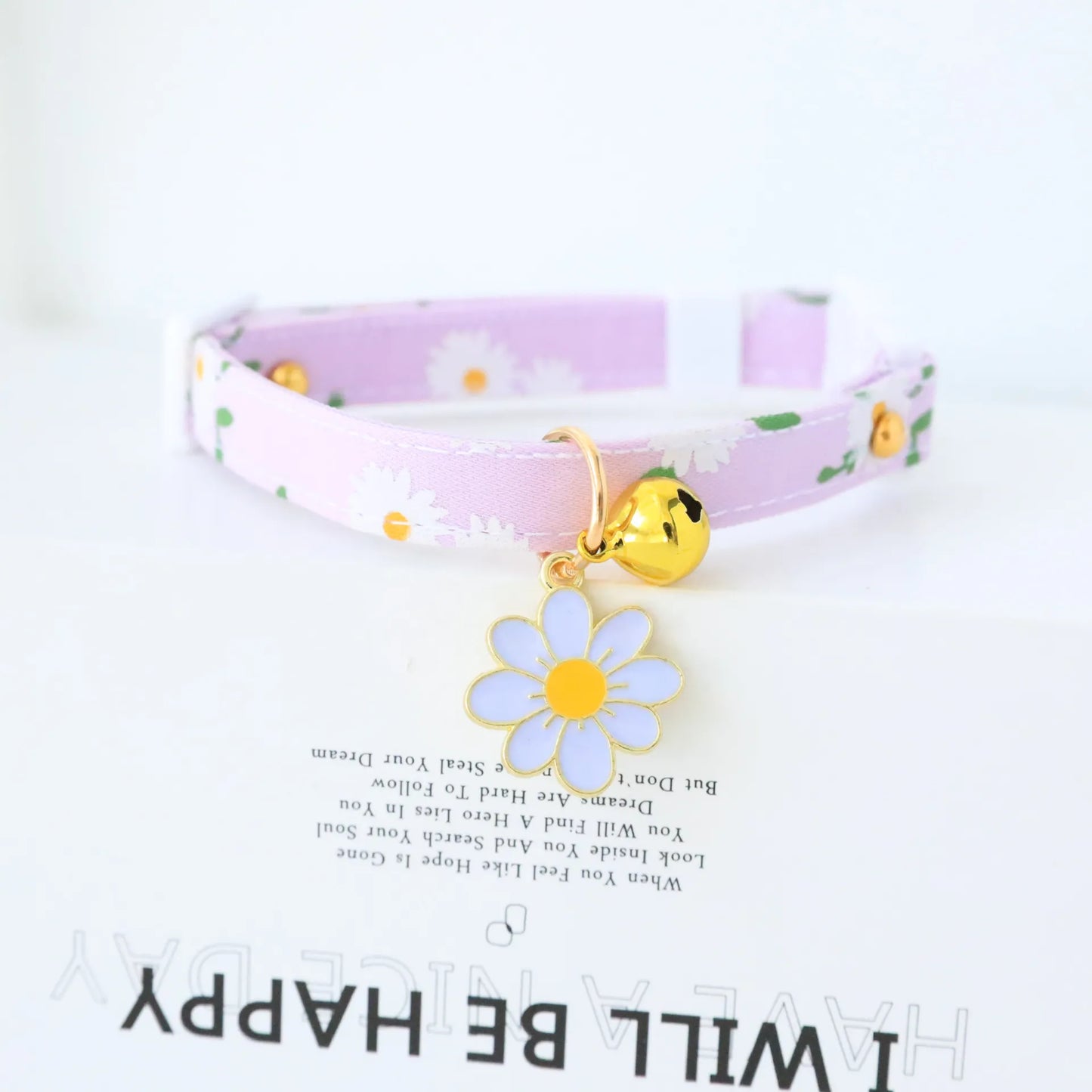 cute light purple cat collar with white flowers on the collar, a bell and a light blue flower shape attached 