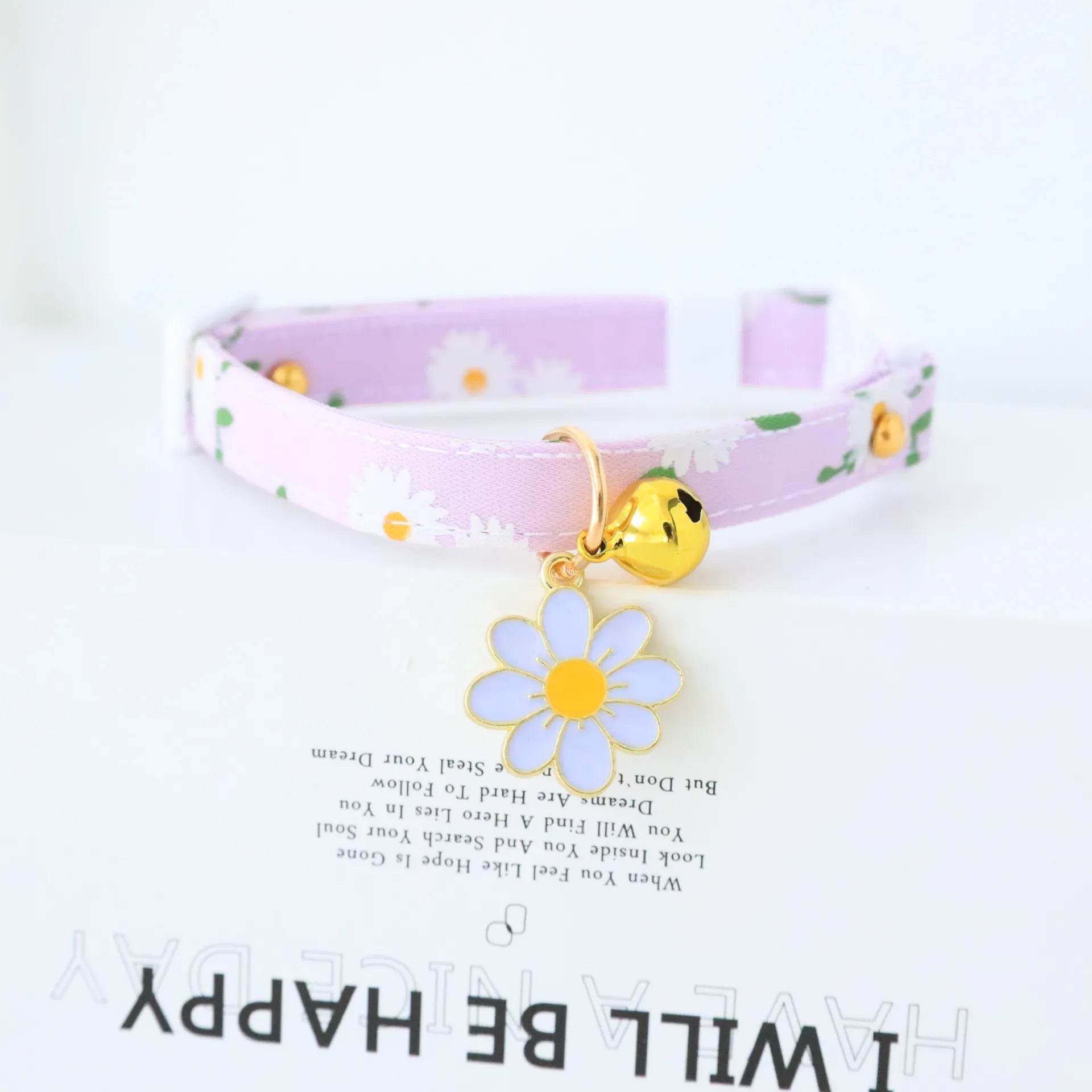 cute light purple cat collar with white flowers on the collar, a bell and a light blue flower shape attached 
