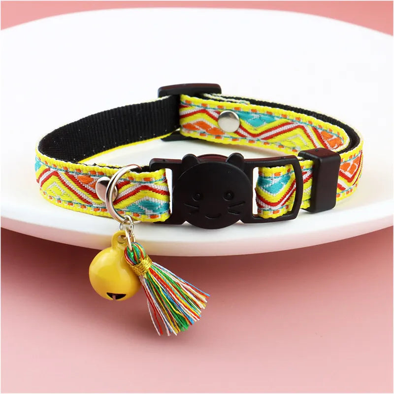 a yellow striped colorful color with a cat face for cats with a jingle bell on it