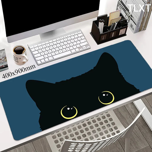 white computer desk with a very cute blue rectangular keypad with drawing of a cute black cat face peaking with cute yellow sparkly eyes 