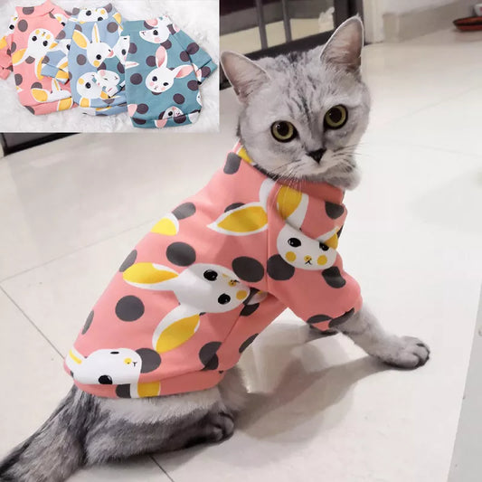 a cute grey cat with a pink comfy cotton pajama costume with white bunny faces on it